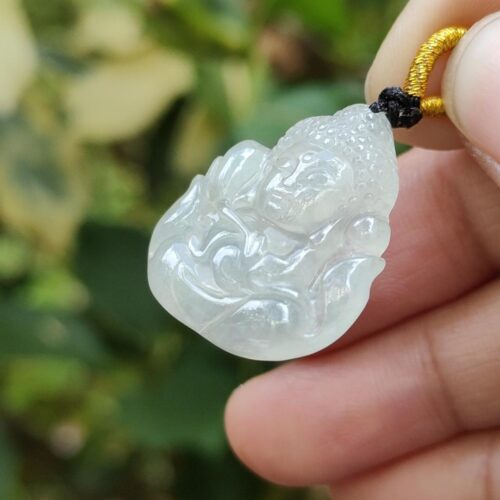 une main tenant un pendentif en jade