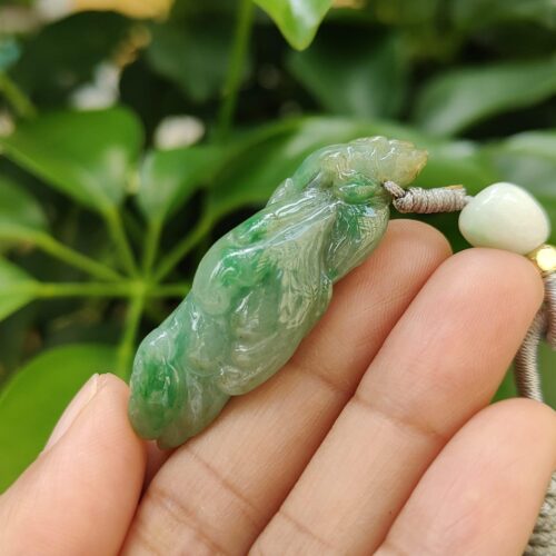 une main tenant un collier de jade