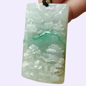 a hand holding a jade pendant