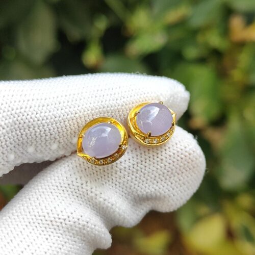 a pair of purple earrings on a gloved hand