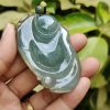a hand holding a jade pendant