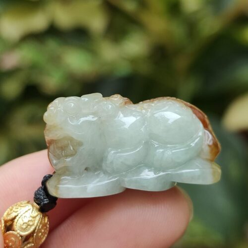 uma mão segurando um pingente de jade