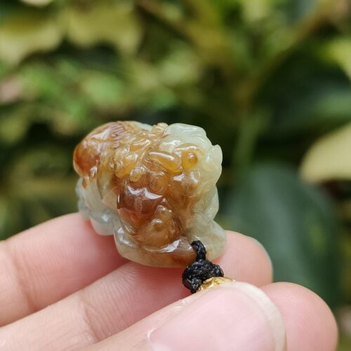 uma mão segurando um pequeno objeto de pedra