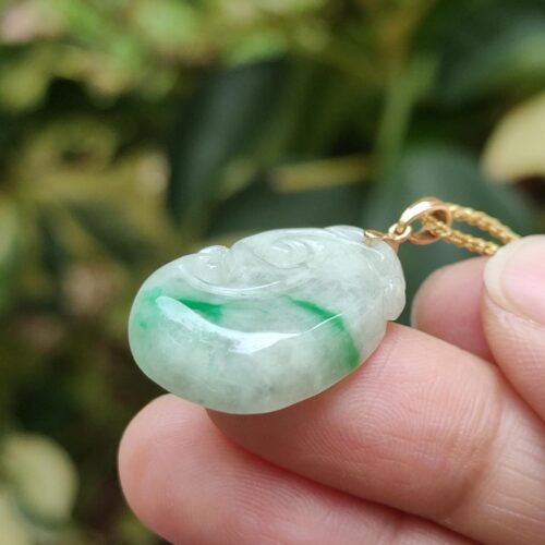 a hand holding a jade necklace