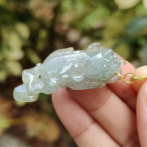 Una mano sosteniendo un colgante de jade.