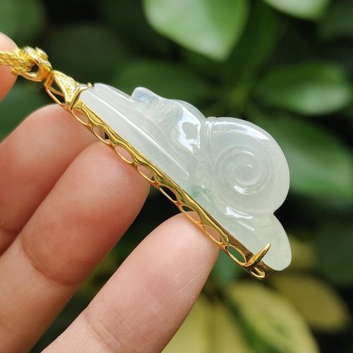 a hand holding a jade pendant