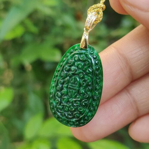 a hand holding a green pendant