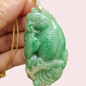 a hand holding a jade pendant