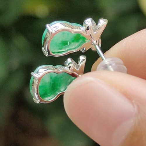 a person holding a pair of earrings