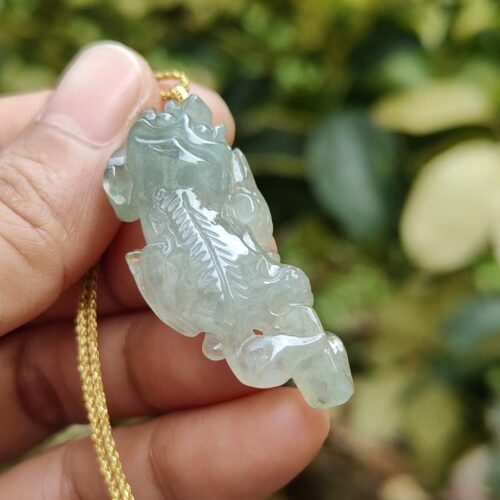 Una mano sosteniendo un colgante de jade.