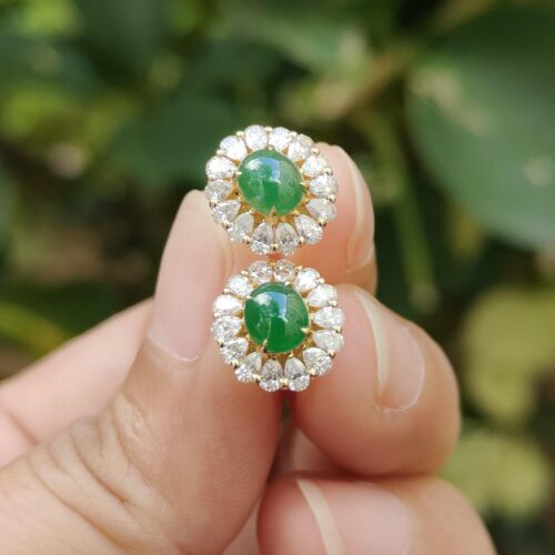 ஒரு ஜோடி காதணிகளை வைத்திருக்கும் ஒரு கை