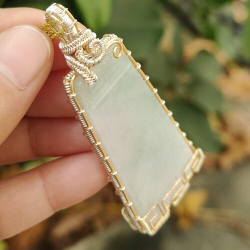 une main tenant un pendentif