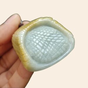 a hand holding a carved object