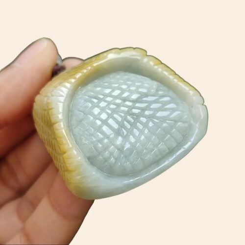 a hand holding a carved object