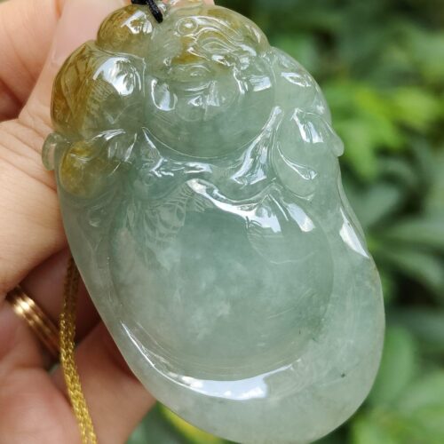 tangan memegang liontin giok