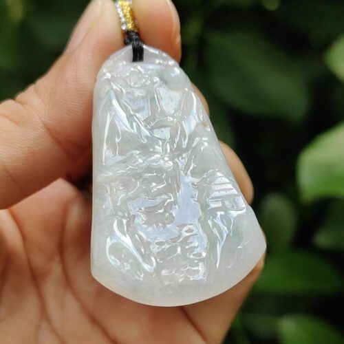 une main tenant un pendentif en jade blanc