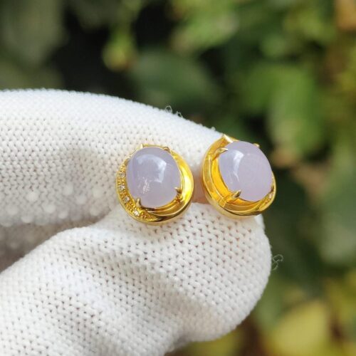 a pair of purple earrings on a white glove