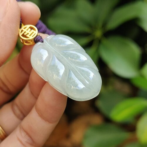 翡翠のペンダントを持つ手