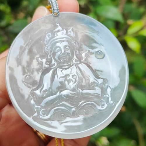 a hand holding a round white pendant