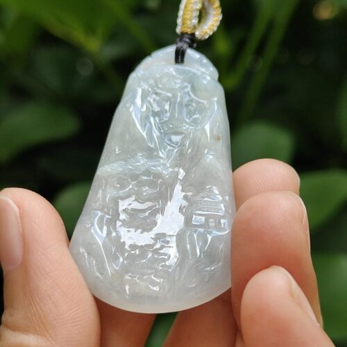 une main tenant un pendentif en jade