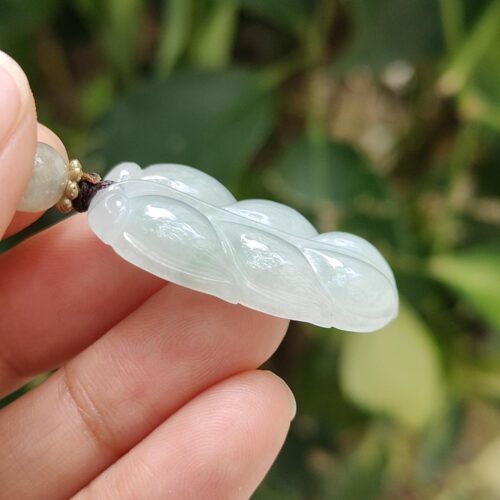 a hand holding a jade necklace