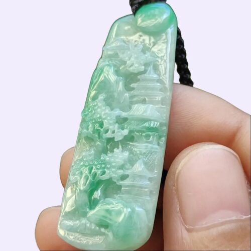 a hand holding a jade pendant