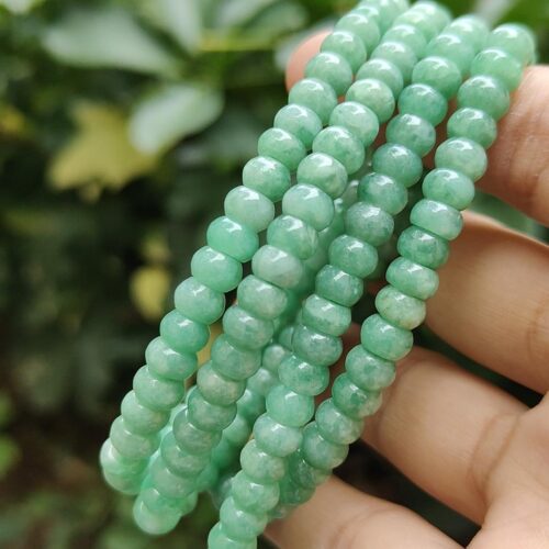 a hand holding a string of beads