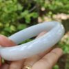 una mano sosteniendo un anillo blanco