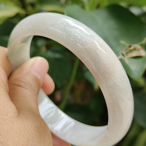 a hand holding a white bracelet