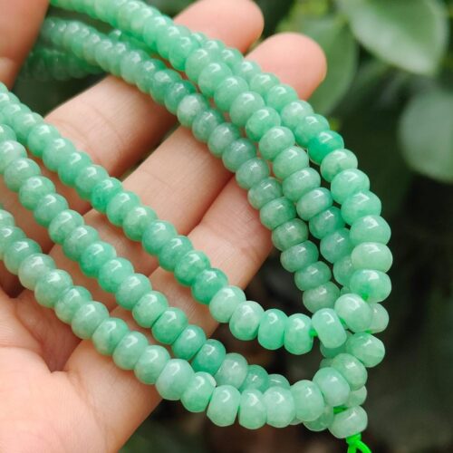 a hand holding a string of beads