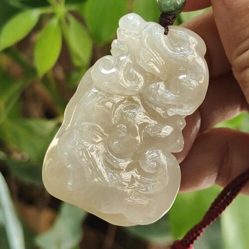 Una mano sosteniendo un colgante de jade.