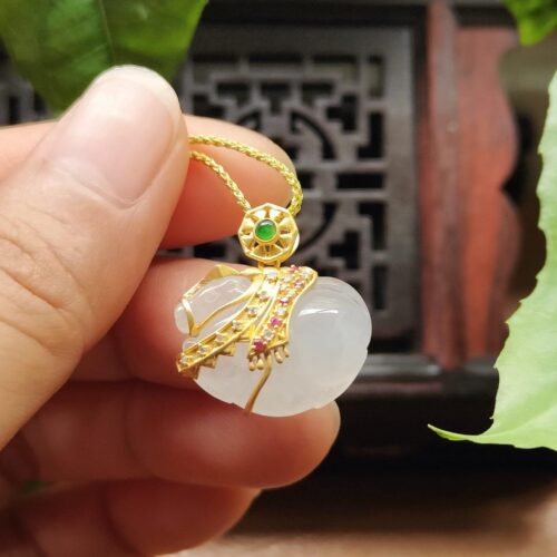 một bàn tay cầm một mặt dây chuyền vàng