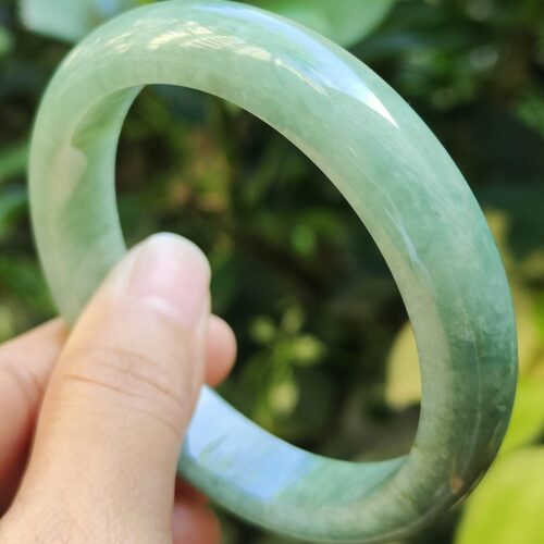 a hand holding a green bracelet