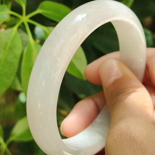 a hand holding a white bracelet