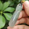 Una mano sosteniendo un colgante de jade.