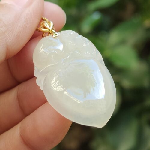 一只手拿着白玉吊坠