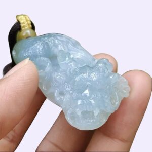 une main tenant une petite pierre bleue