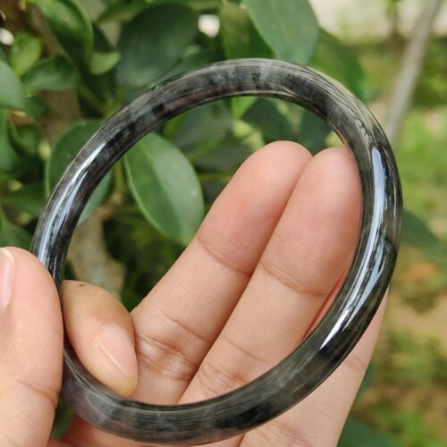 a hand holding a black ring