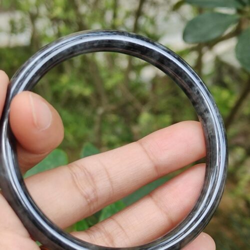 a hand holding a round black ring