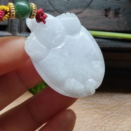 Una mano sosteniendo un colgante de jade.