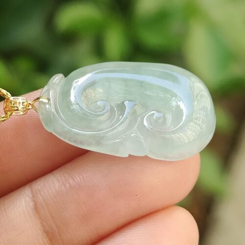 một bàn tay cầm một chiếc vòng cổ ngọc bích