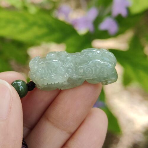 翡翠のネックレスを握っている手