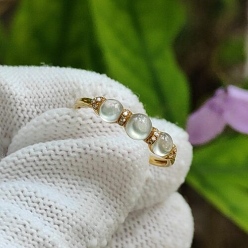 a hand wearing a white knitted glove with a ring