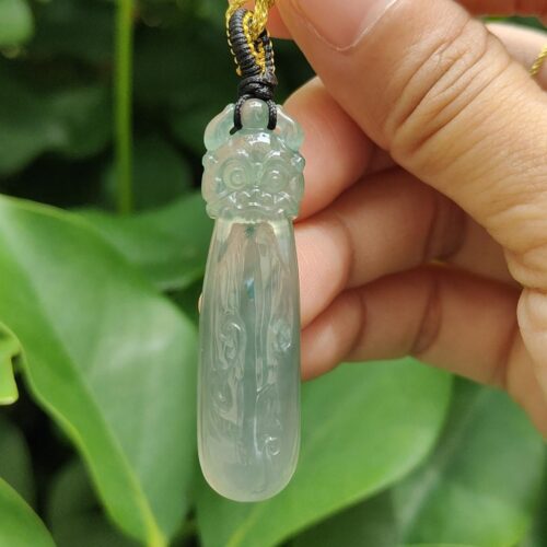 Una mano sosteniendo un colgante de jade.