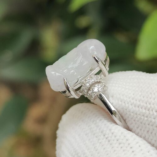 a hand wearing a white glove with a white stone ring