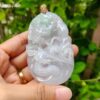 a hand holding a jade pendant