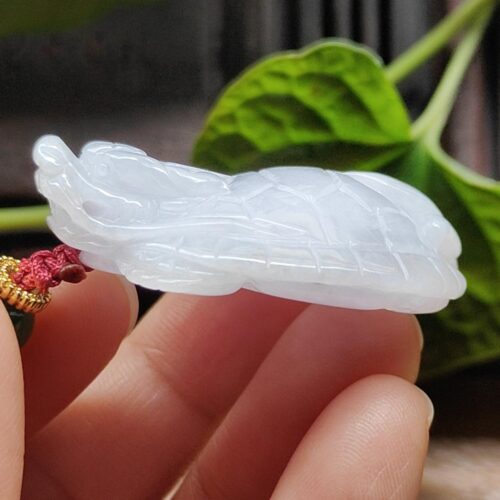 a hand holding a white jade necklace