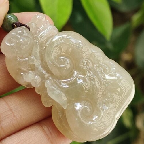 Una mano sosteniendo un colgante de jade.