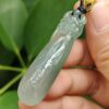 Una mano sosteniendo un colgante de jade.