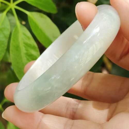 a hand holding a white bracelet